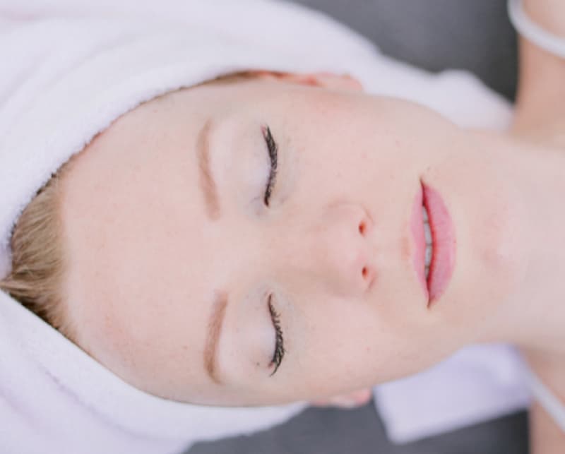 Femme détendue, serviette sur les cheveux, après un massage crânien