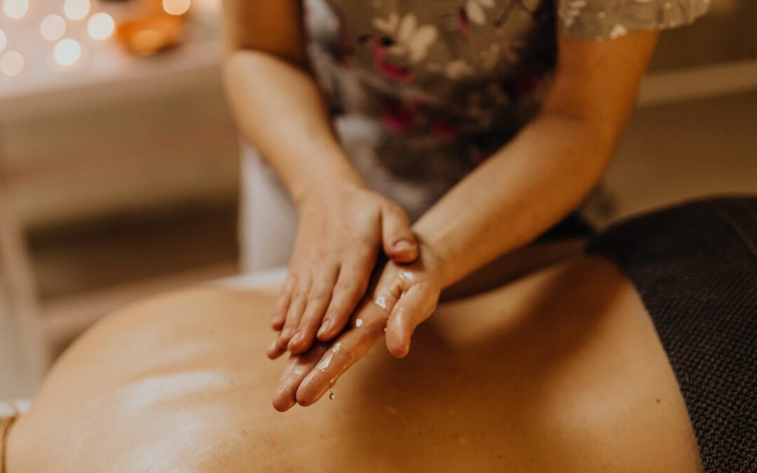 Mains qui massent un dos huilé pendant un massage bien-être à Lyon