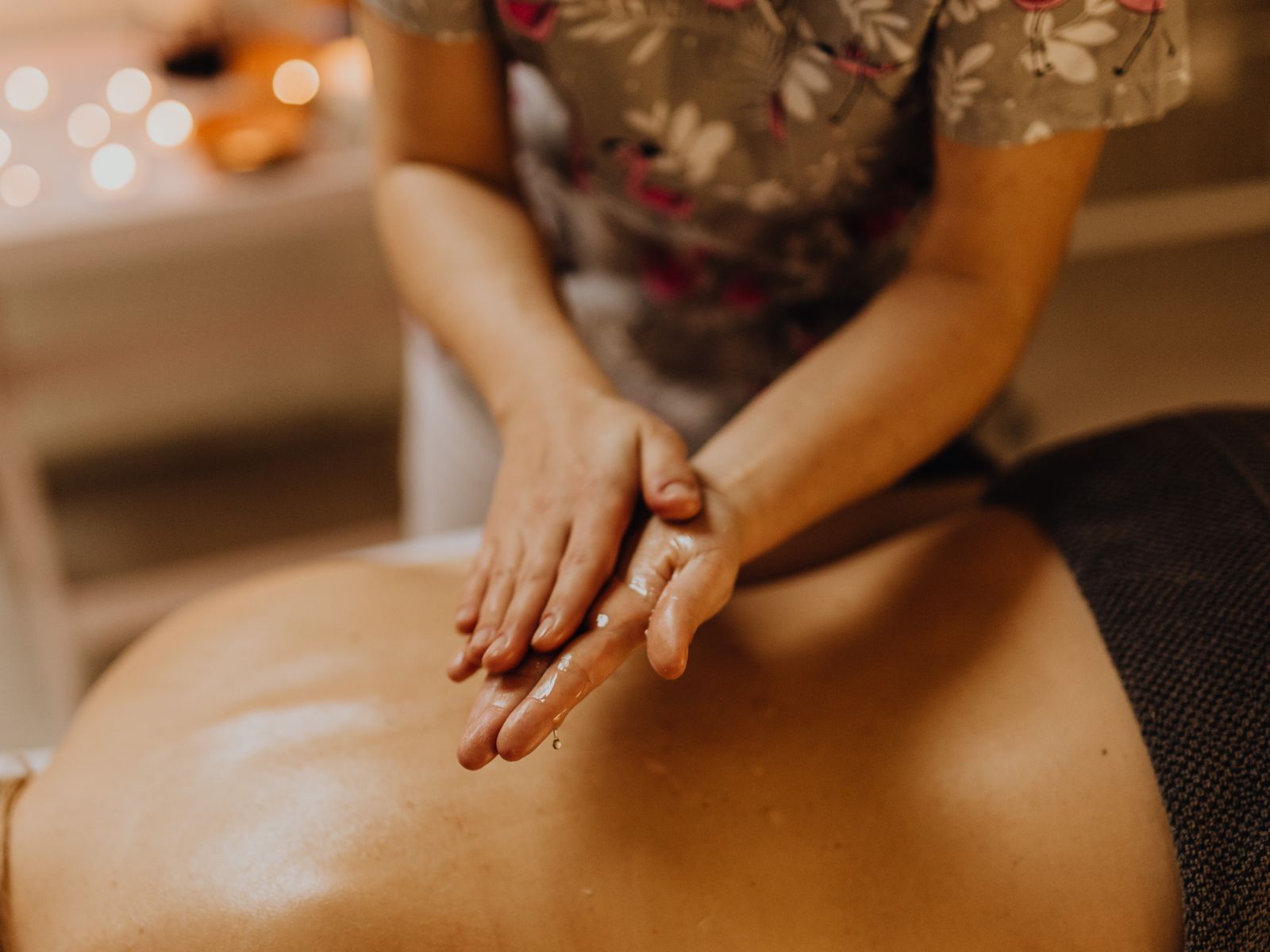 Mains qui massent un dos huilé pendant un massage bien-être à Lyon